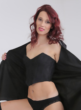 Redheaded girl with small tits exposing everything on a big bed